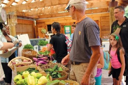 High school families, children’s program participants, and community members line up at Common Ground’s summer farmstand