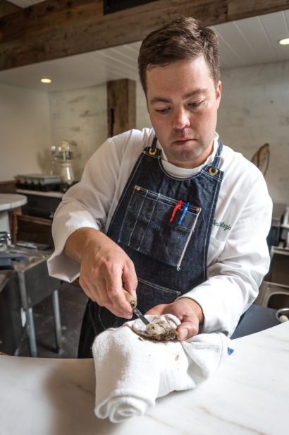 Executive Chef Geoff Lazlo prepares an oyster for the raw bar at Mill Street